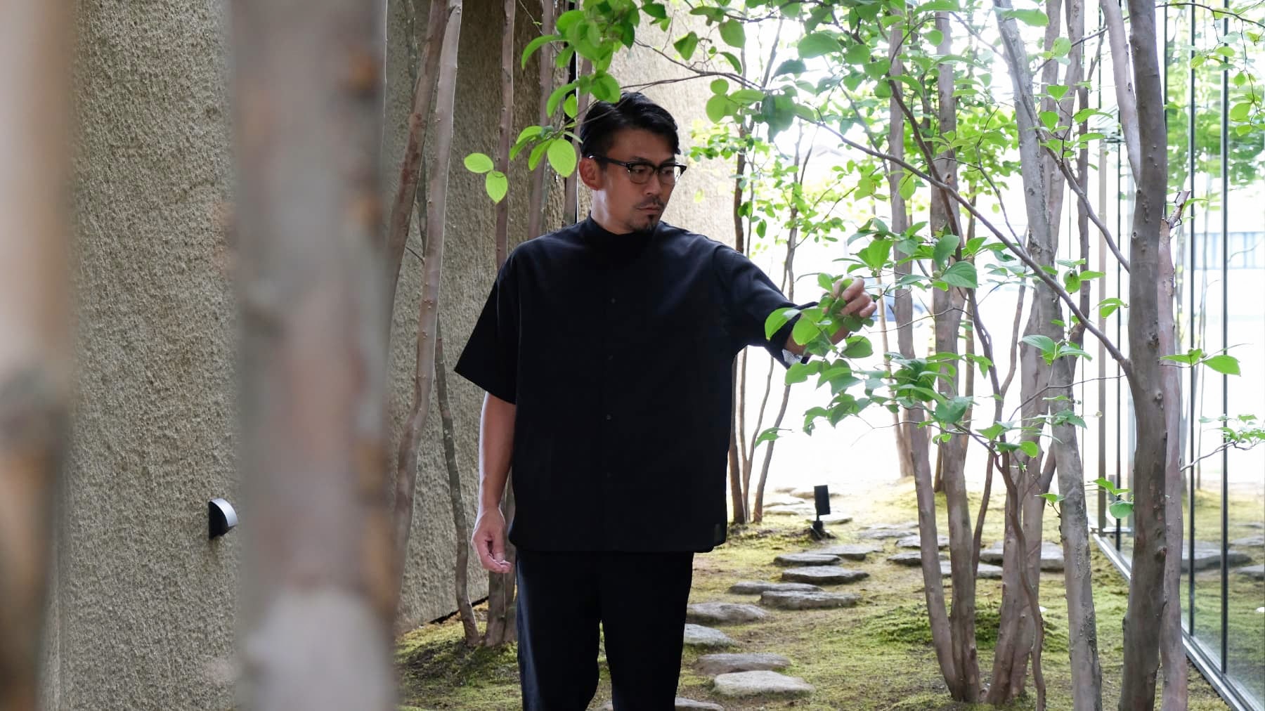 代表:羽田氏がシャラの木に触れている写真